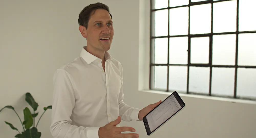 Leonard Goldberg, founder of Settlement Insight, presenting settlement data on a tablet